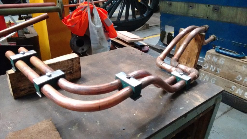A curved section of copper-coloured pipework from locomotive Sir Nigel Gresley.