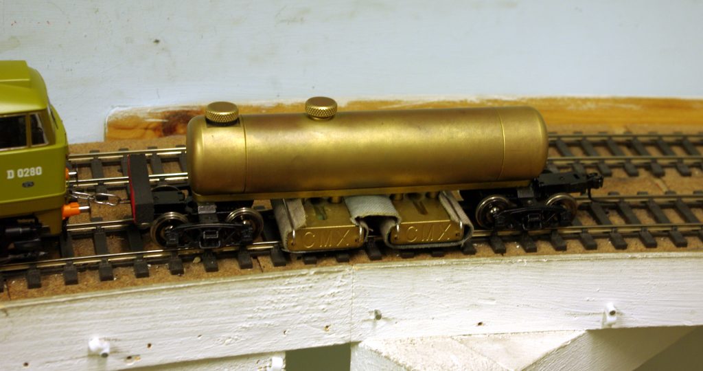 A brass track cleaner on the track of the model railway