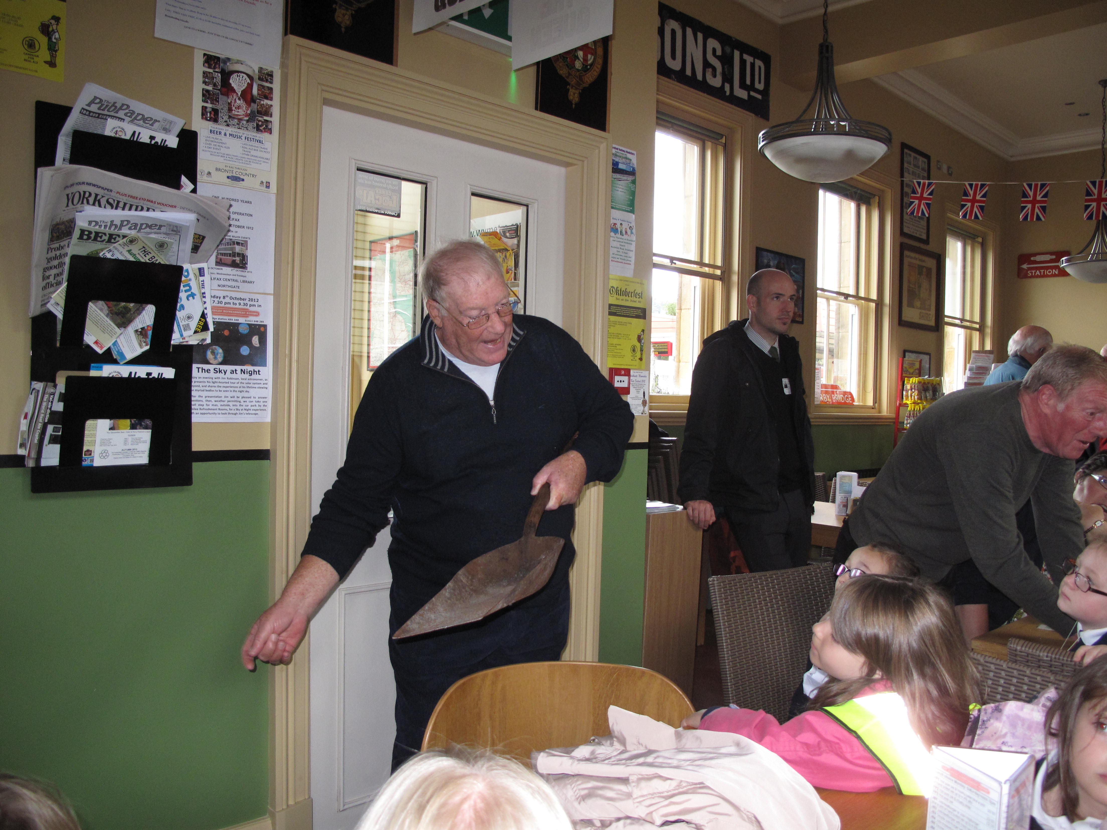 A former fireman demonstrates shovelling coal.