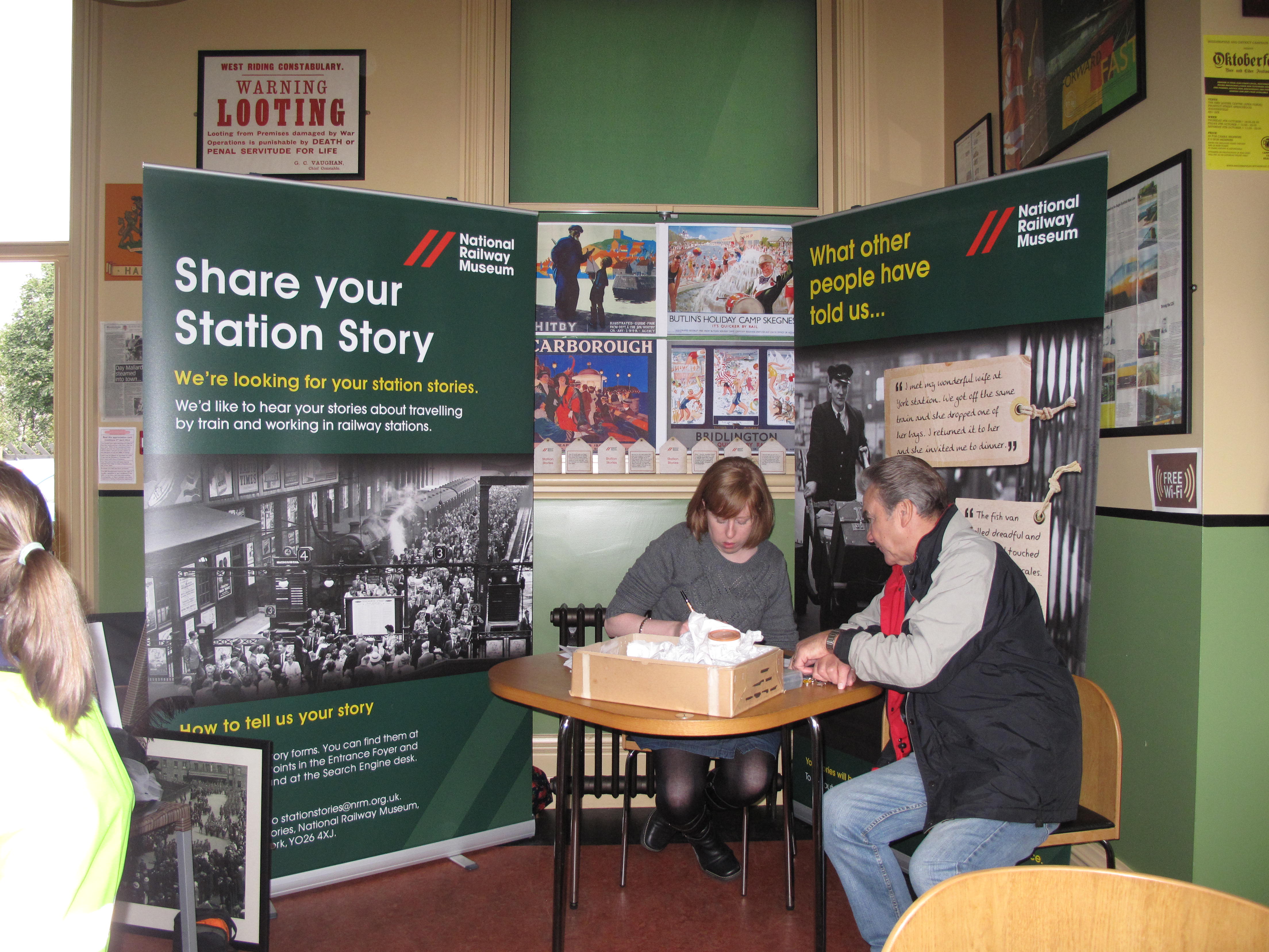 Museum volunteer Verity Smith writes down a station story.