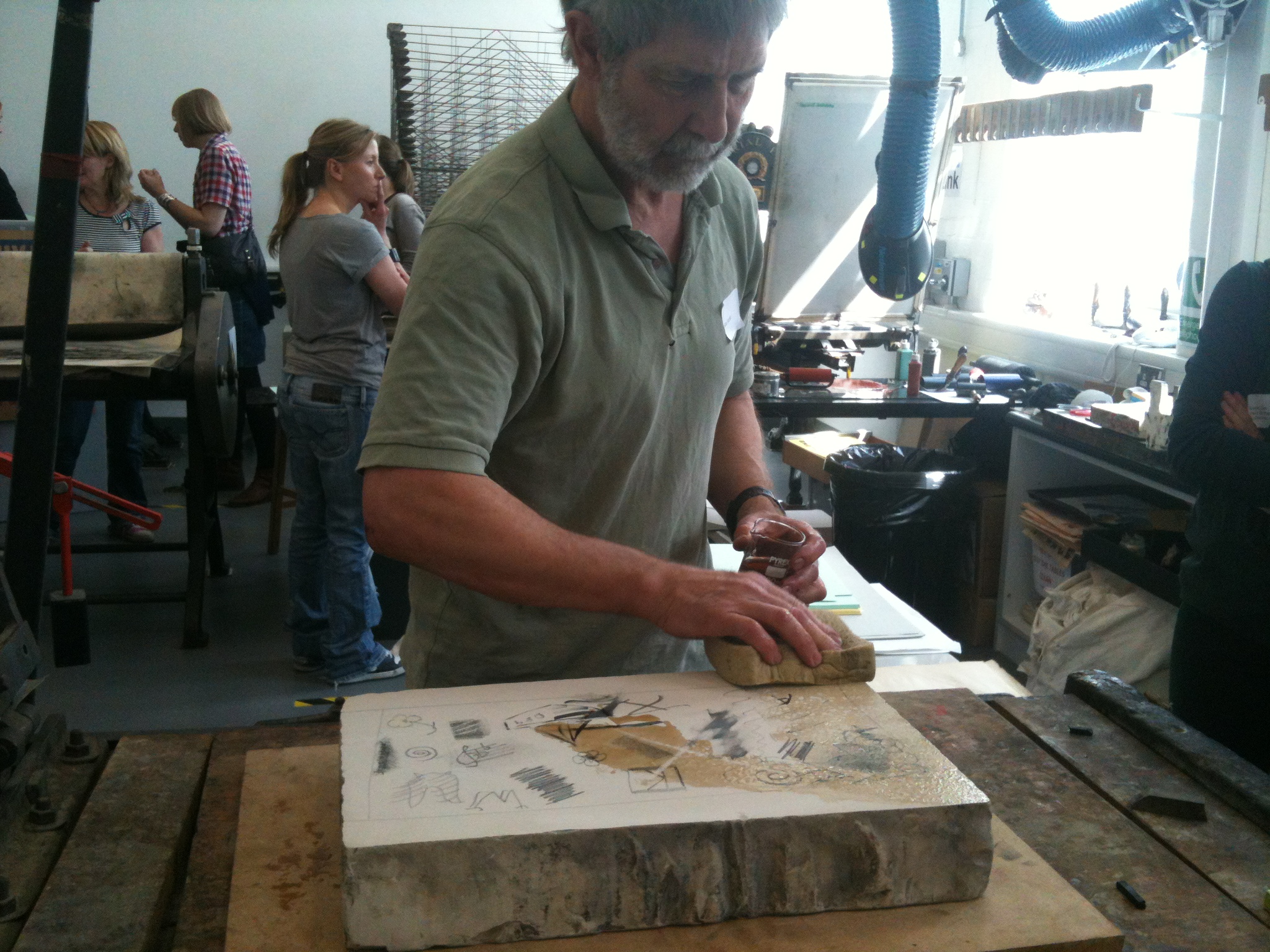 The stone is chemically treated and damped before it is ready for inking.
