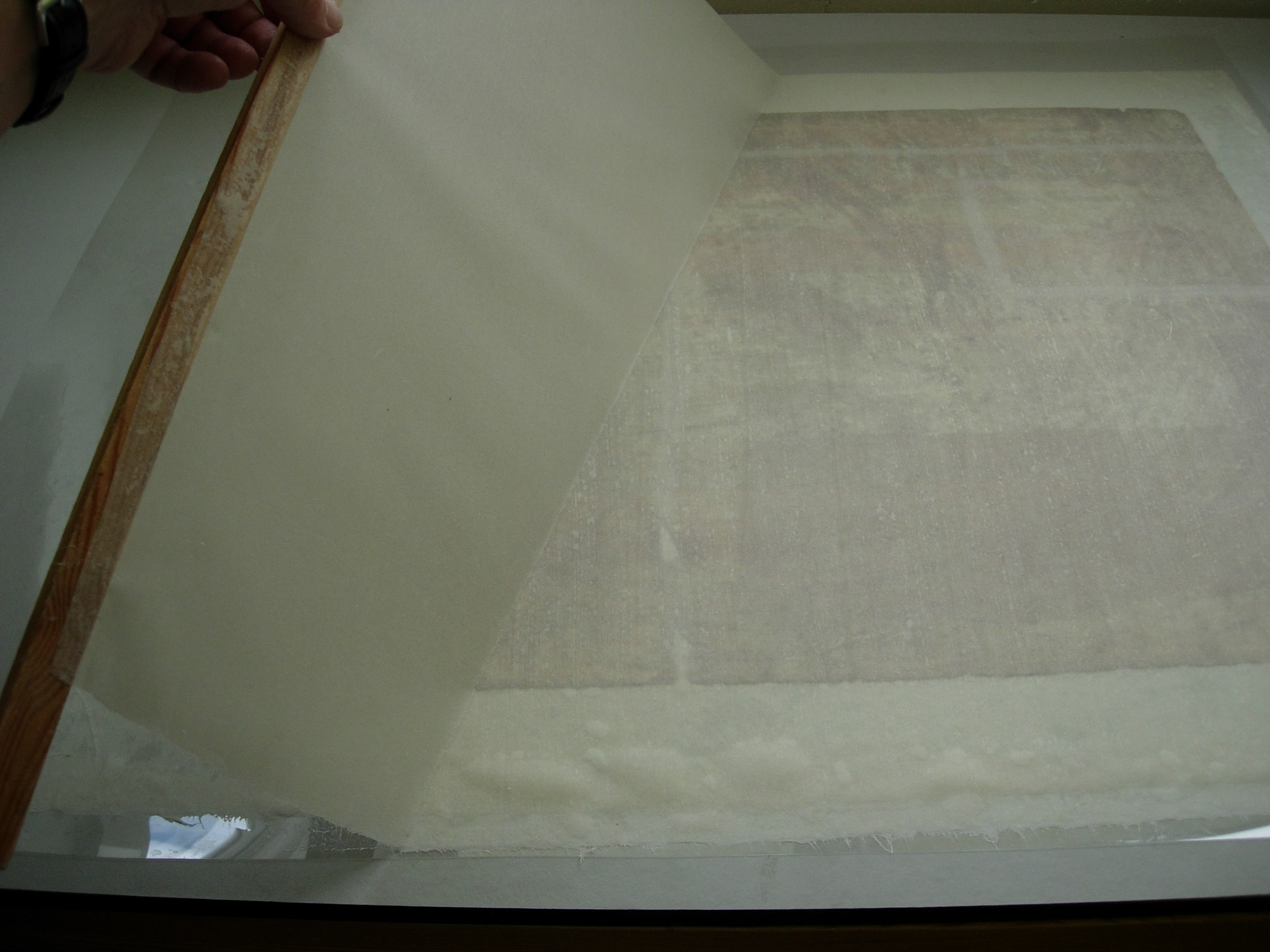 Blackpool poster, during conservation, applying lining of Japanese paper
