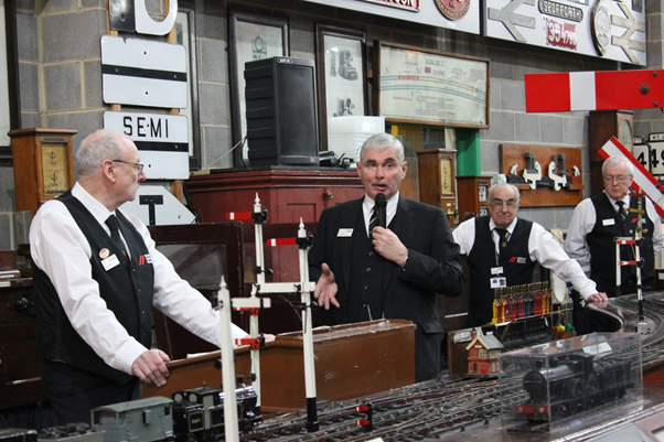 School of Signalling Model Railway volunteers Alan Lewis, Dave Eastoe, Bob Wright, led by Phil Graham, microphone in hand, as he sets the scene for the reconstruction of the collision at Heighington. (Image Copyright National Railway Museum)