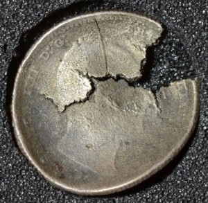 A coin salvaged from the considerable wreckage - warped by the intense fire.
