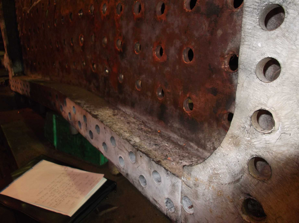 The outer wrapper side sections have been removed exposing the foundation ring and the copper sides to the firebox