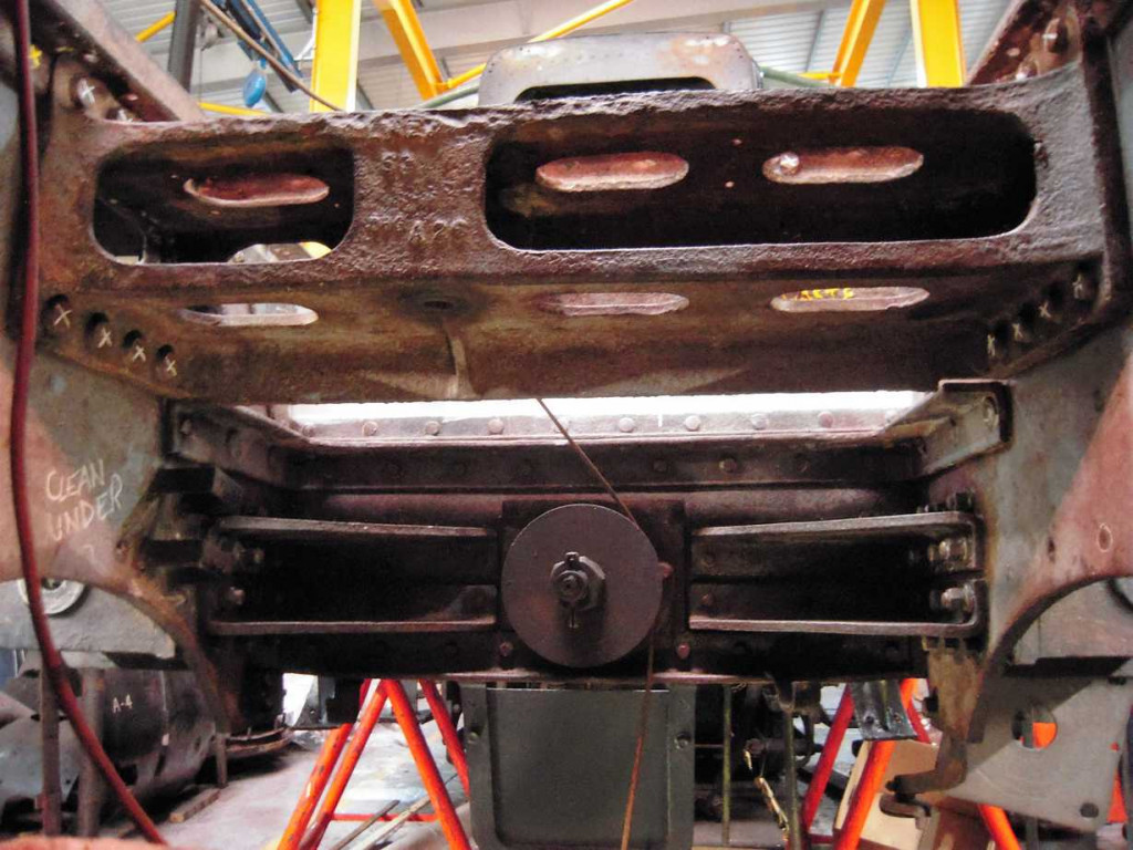 A view behind the front bufferbeam. The frames in this area are now receiving paint. White undercoat has been applied to the plates above the central disc which is the end of the spring assembly for the front coupling hook