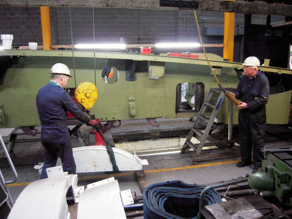 Dave Lee and Bob Shearman lift one of the splashers during refitting.