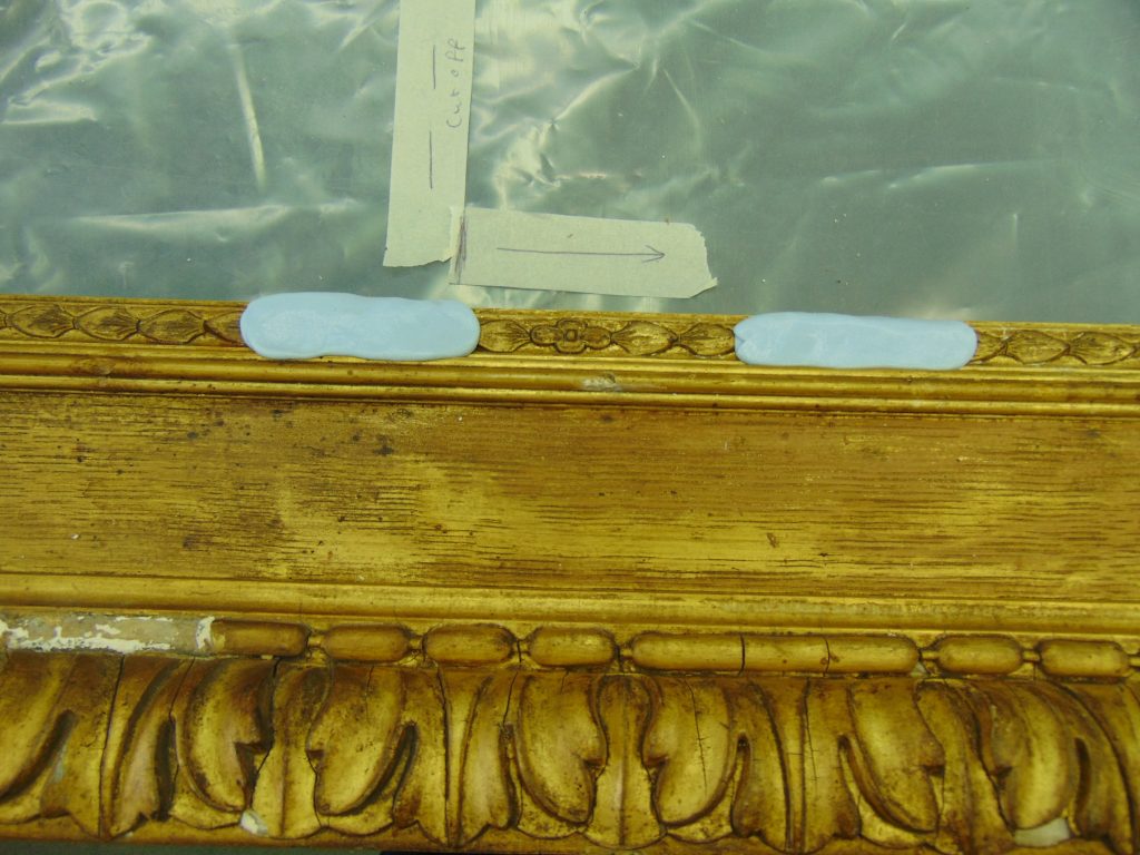 A gilt picture frame with light-blue Steramould substance applied in small areas