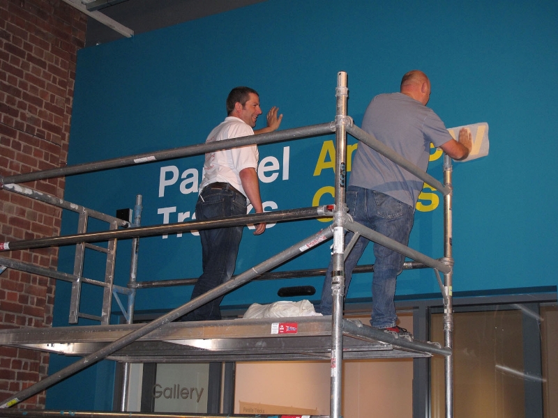Martin and Phil from Digital Plus install the exhibition title on the outside of the gallery.
