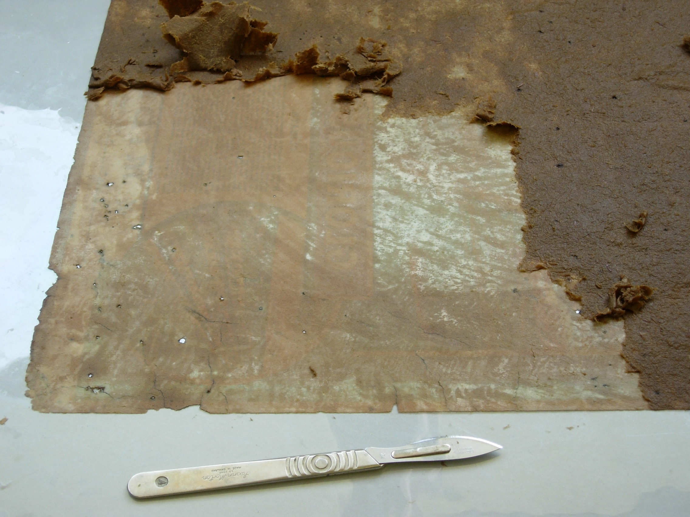 Blackpool poster, during conservation, removing old strawboard residue whilst wet