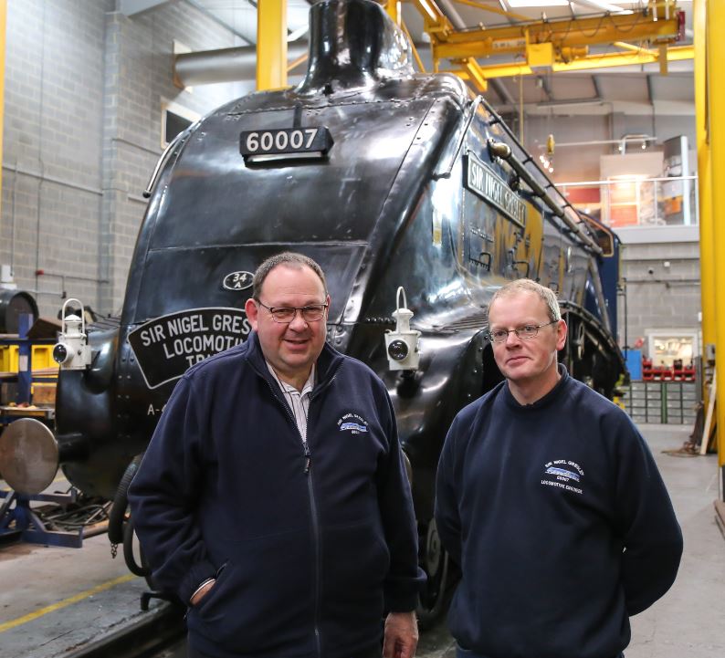 John Wilkinson (left) and Darrin Crone stand proudly on The Works floor in front of the loco.