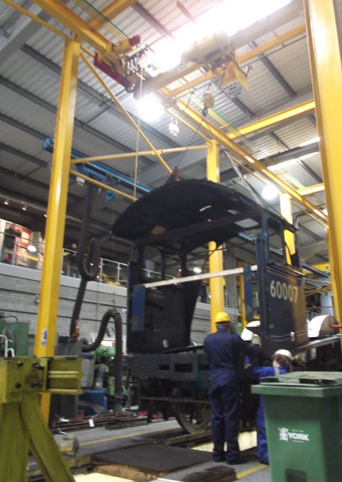 Jon Gray and Tom Crone fastening the cab down on to the frames while supported by the crane.