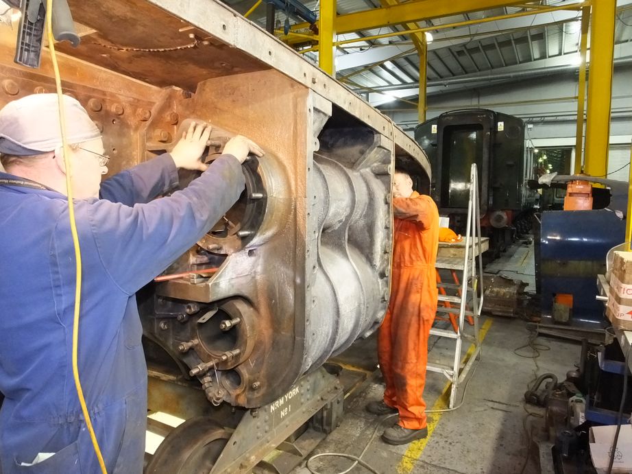 Andy Lowes, furthest from the camera, knocks out the trailing right-hand valve liner towards Darrin Crone, who steers it out of the cylinder casting.