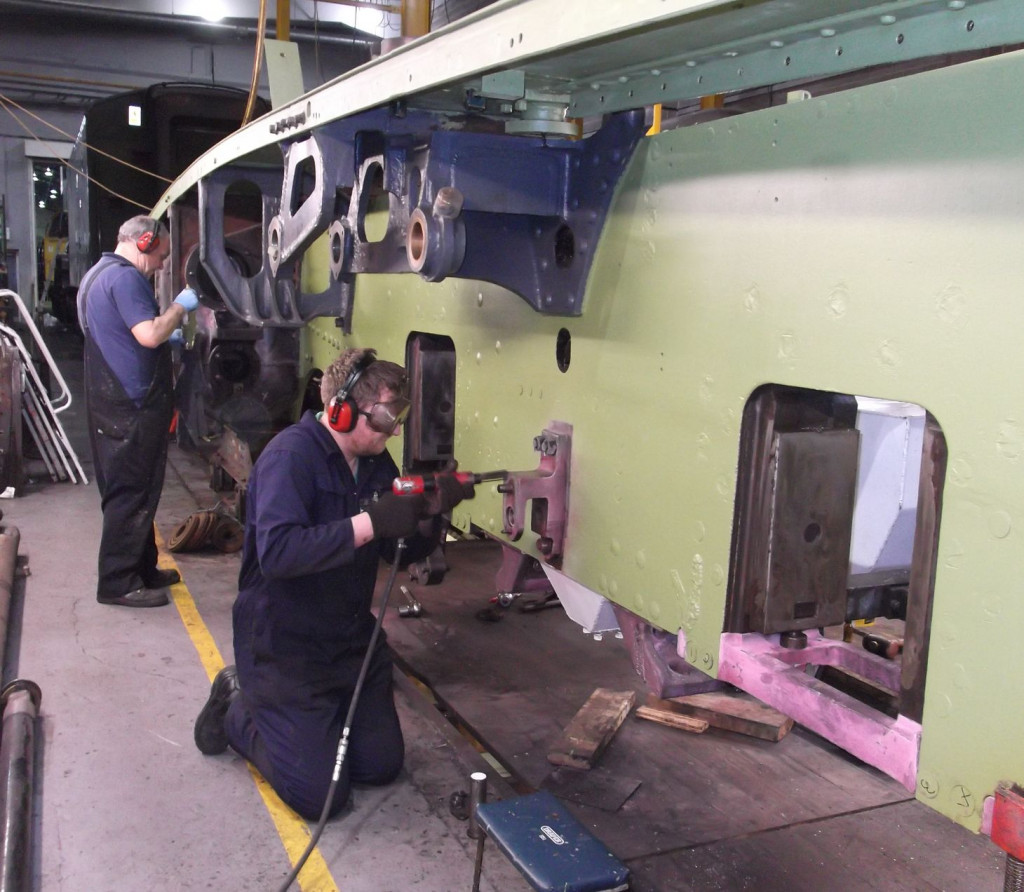 Peter Brackstone paints while Daryl Nichol prepares a section of brake hanger bracket for further examination