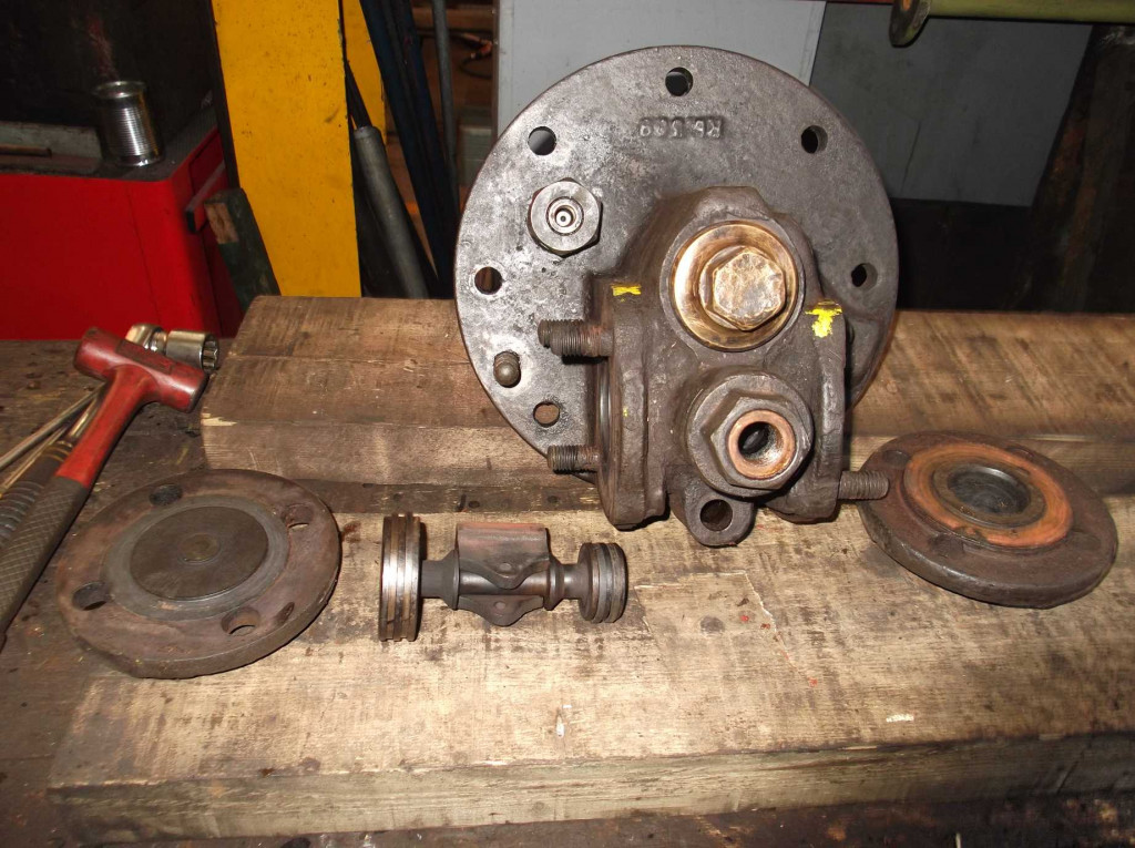 The top cover removed. This is on the top end of the steam cylinder where the mechanism is located that directs steam to either side of the steam piston. Some of the components for this mechanism are laid out.