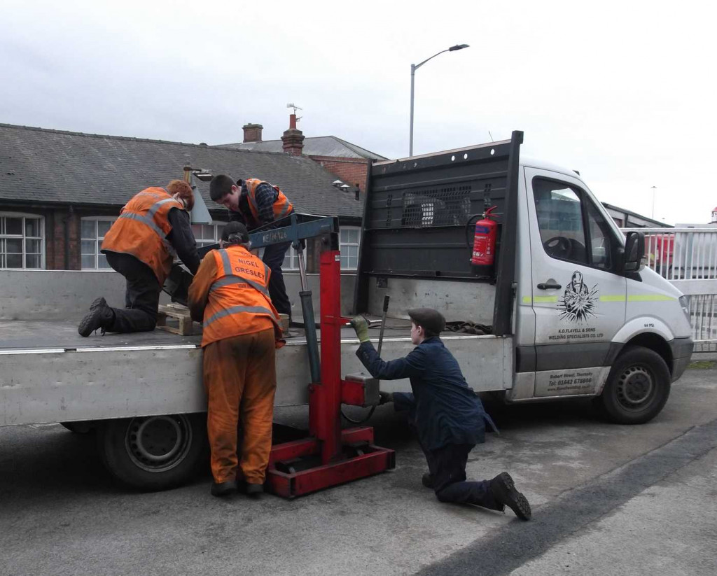 The right-leading brakeshaft and spring bracket is loaded on to K D Flavell's van for taking away for refurbishment. It is loaded by Finn Allen on the engine hoist and tied down on a pallet by Ethan Humble and Tim Noble, supervised by CME Richard Swales.
