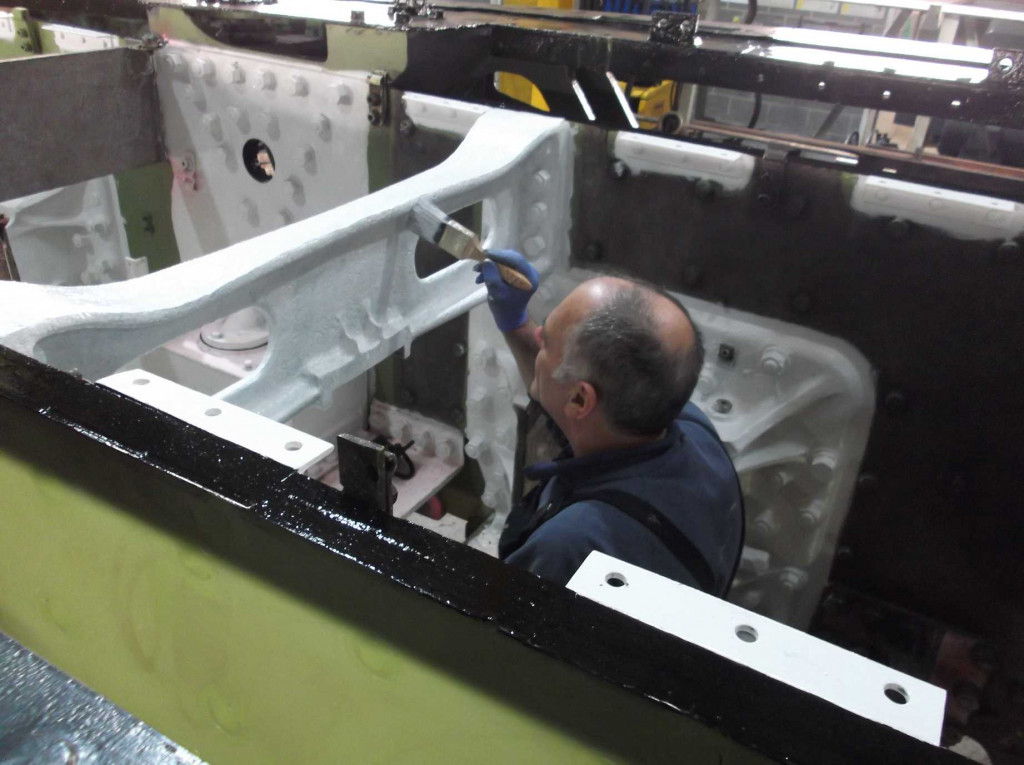 The splasher brackets and frame tops are painted so that the splashers can be refitted. Peter Brackstone, Painting Team Leader, applies undercoat to the middle cylinder slide bar bracket.