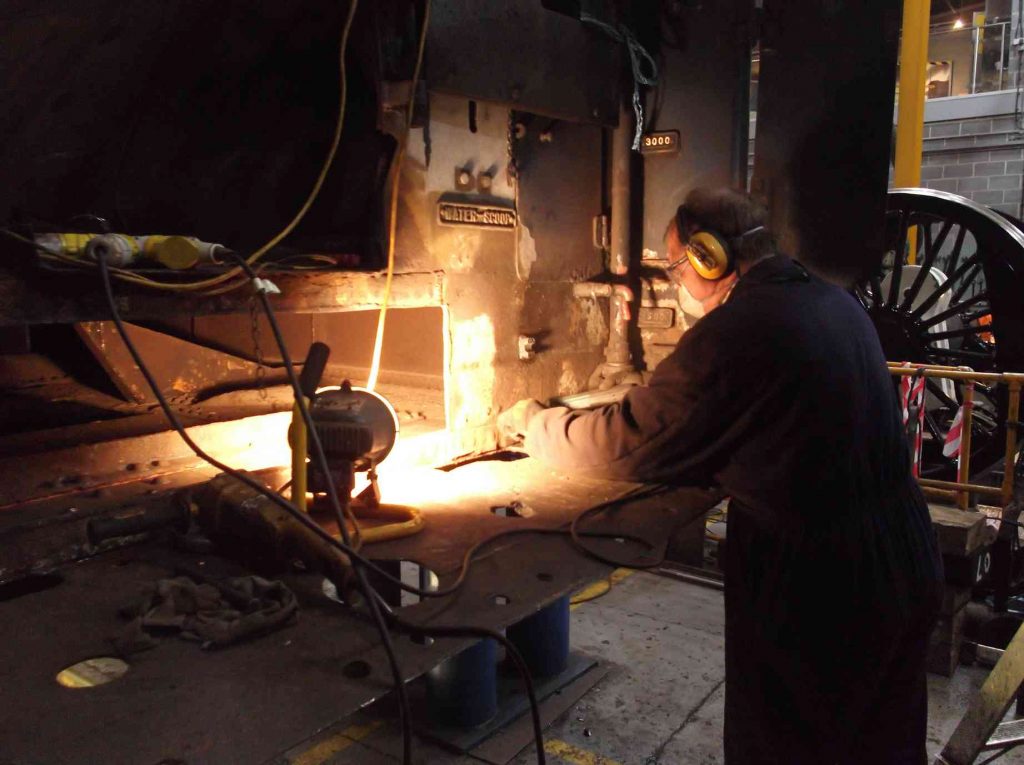 Work continues on wasted material at the front of the tender