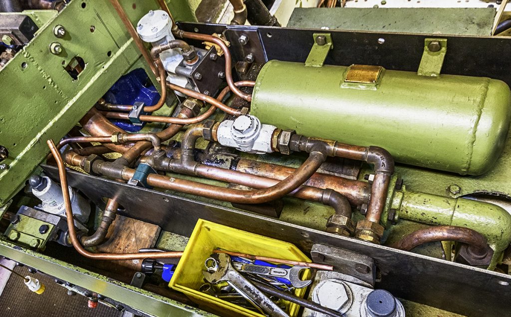 Work on the pipes below the cab floor continues
