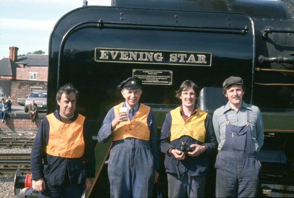 Four men standing in front of a locomotive
